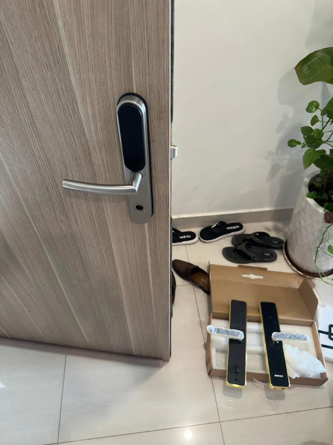 Kỹ thuật viên đang lắp đặt khóa vân tay tại căn hộ Vinhomes Grand Park, Quận 9